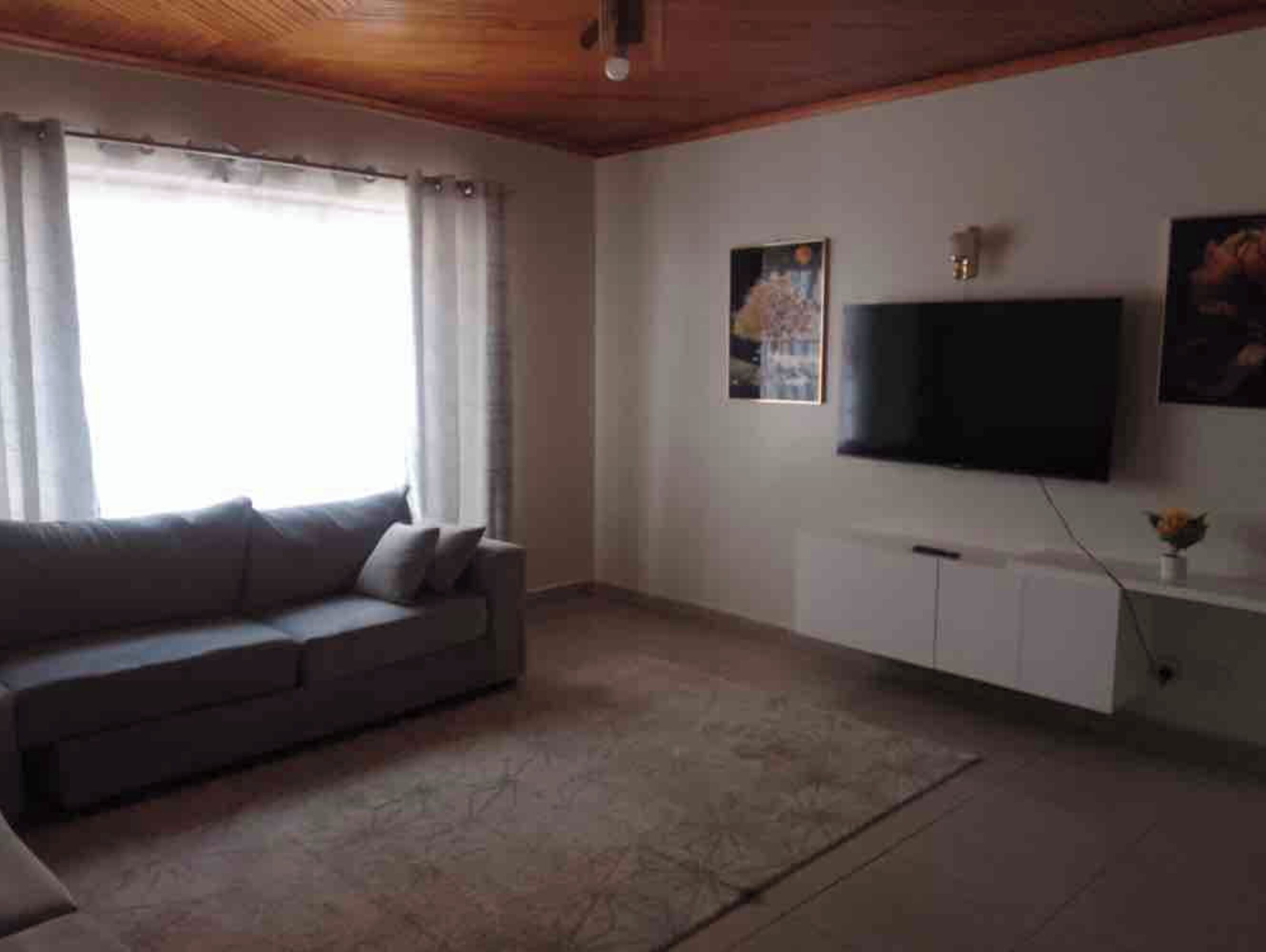 A living room with a sofa, a TV, and a cabinet.