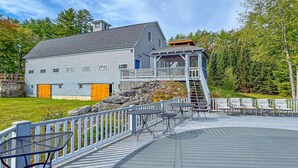 A large house with a deck and outdoor seating area. - Huge Farmhouse Estate on South Pond with Extreme Privacy: Host Weddings (Buckfield)
