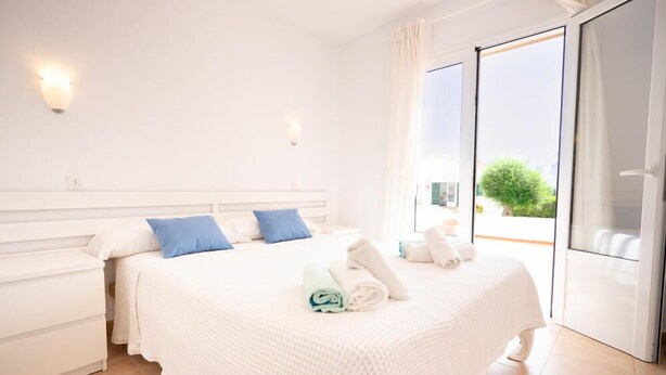 Une chambre d’hôtel avec un lit, une table de chevet et une vue sur l’extérieur.