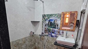 Un bagno con pavimento in marmo, lavandino, doccia e uno specchio decorativo.