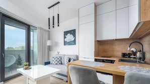 Un appartement moderne comprenant un coin repas, une cuisine et un balcon avec vue.