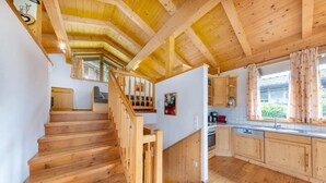 Un intérieur en bois avec un escalier menant à une cuisine.