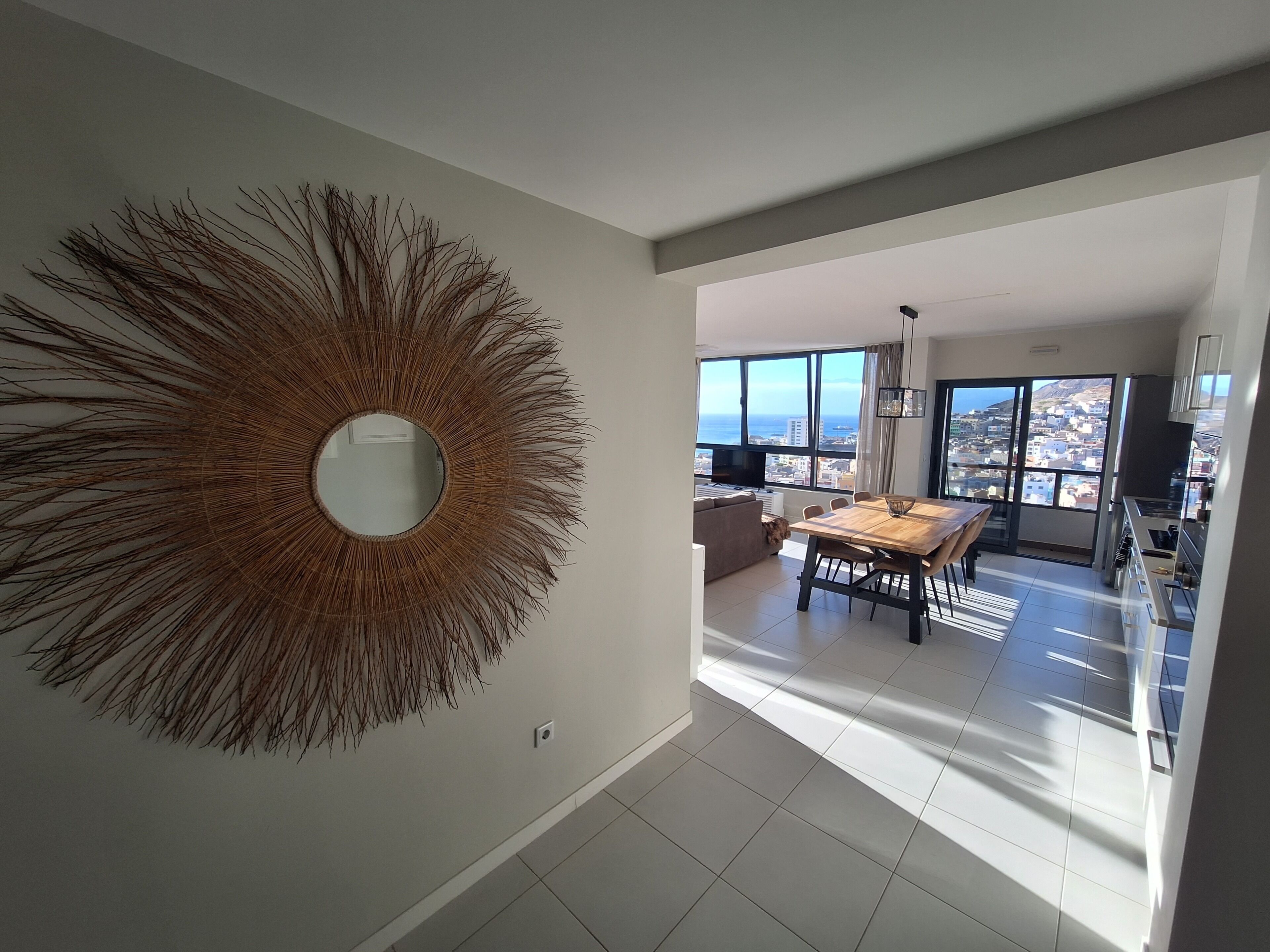 Un appartement moderne doté d’un grand miroir, d’un coin repas et offrant une vue sur la ville.