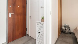 Ein Flur mit einer Holztür, einer weißen Wand und einem Ventilator.