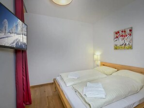 Een hotelkamer met een bed, een schilderij en een wandlamp.