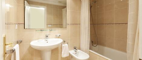 A modern bathroom with a sink, bidet, and shower.