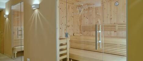 Una sauna con bancos de madera y un panel de vidrio.