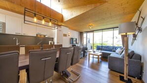 Una cocina moderna con gabinetes de madera y un comedor con sillas y una mesa.