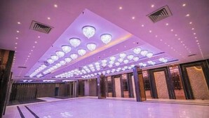 A spacious hotel lobby with a high ceiling, multiple chandeliers, and a polished floor. - Krishna Valley Wellness Resort Vrindavan (Mathura)