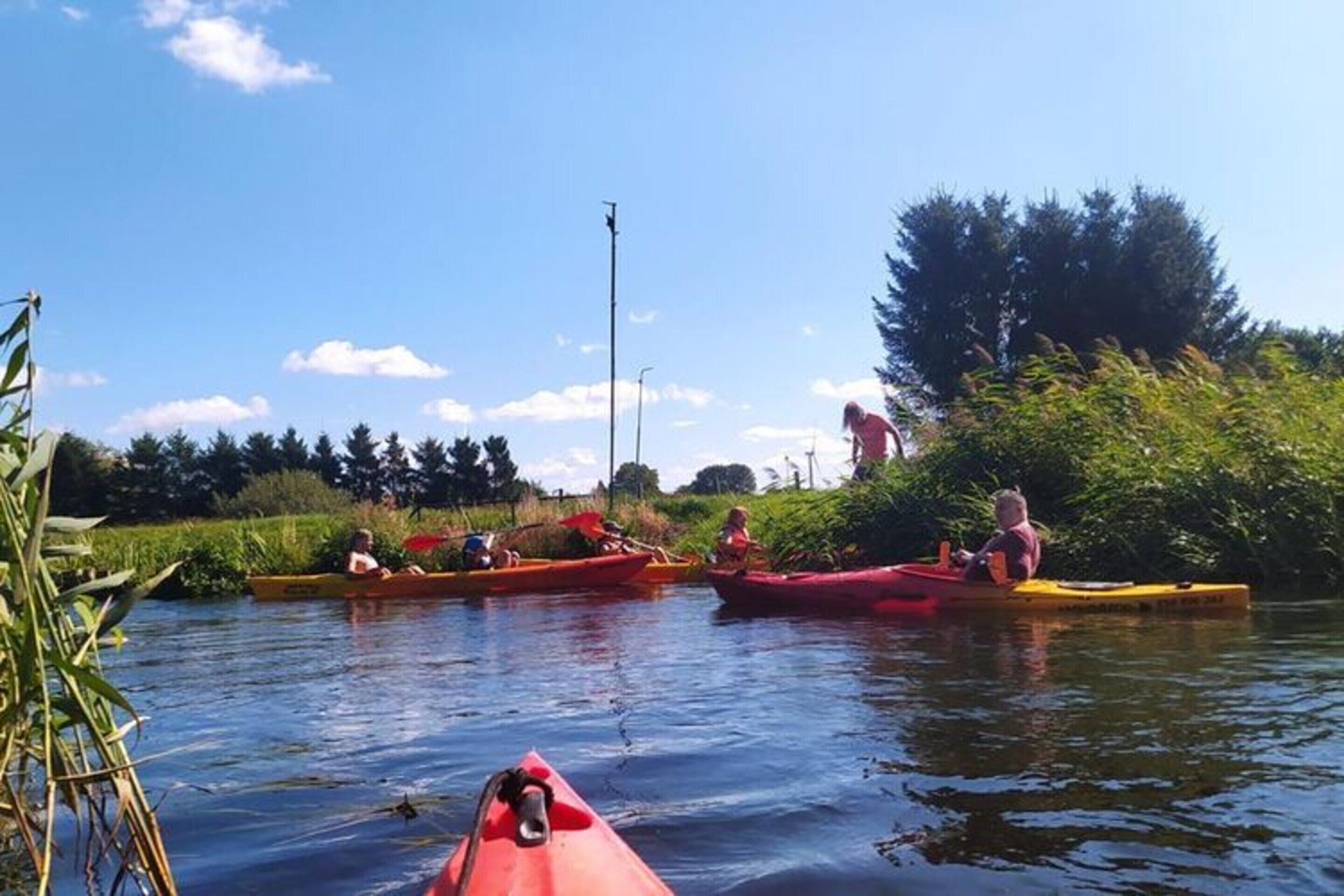 Un río tranquilo con kayaks y canoas.