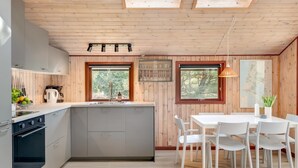 Eine moderne Küche mit einer zentralen Kochinsel, Holzwänden und Dachfenstern.