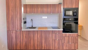 Une cuisine moderne avec des meubles en bois, un four à micro-ondes encastré et un four double.