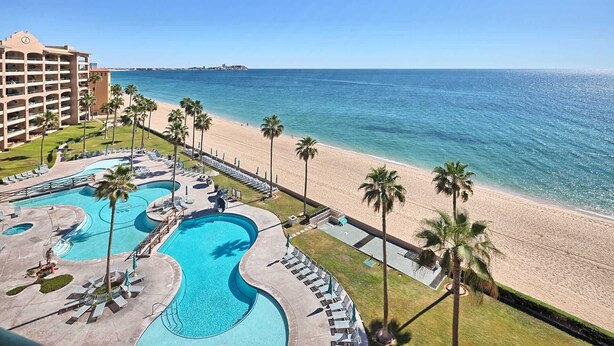 Ein Resort mit großem Pool, einem Strand und Blick aufs Meer.
