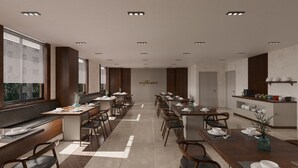 A modern dining area with multiple tables and chairs, a kitchen counter with dishes, and a large window with blinds. - EUPHRATES HOTEL (Bursa)