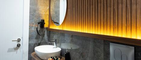 Une salle de bain moderne avec un meuble-lavabo en bois, un grand miroir ovale et un radiateur encastré.