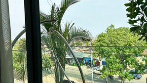 Ein modernes Zimmer mit großem Fenster, einem Hängesessel und Blick auf die Straße.