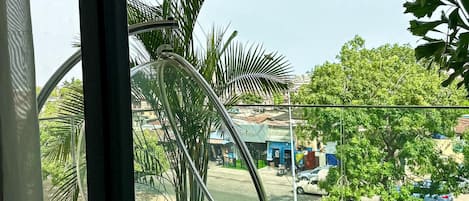 A modern room with a large window, a hanging chair, and a view of the street outside.