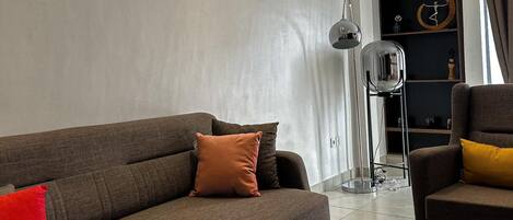 A modern living room with a sectional sofa, a coffee table, and a floor lamp.