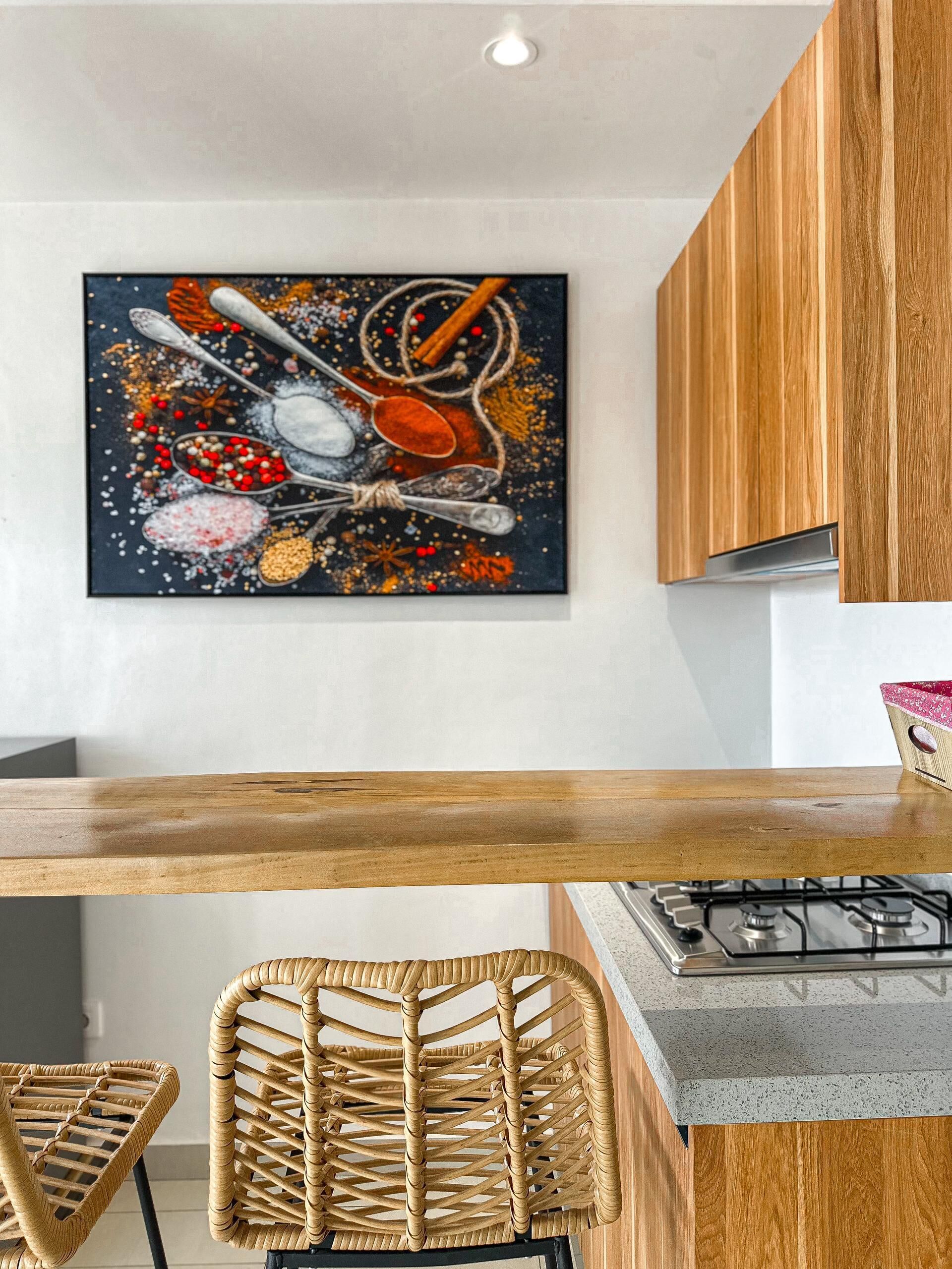 Una cocina con encimera de madera, cocina a gas y una silla de mimbre.