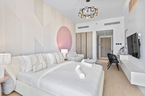 Een moderne hotelkamer met een groot bed, een bureau met stoel, een televisie en een decoratieve wand.