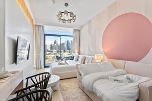 Een moderne hotelkamer met een groot bed, een zithoek, een eethoek en uitzicht op de stad.