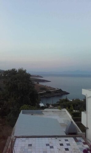 A rooftop with a tiled floor, overlooking a coastal area with a view of the sea and distant land. - Egli's boutique (Lavreotiki)