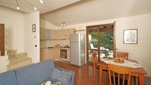 Eine moderne Küche mit Essbereich, einer Couch und einer Treppe zu einer weiteren Ebene.