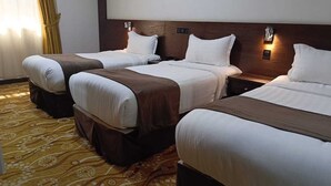 A hotel room with three single beds, a wooden headboard, bedside lamps, and a patterned carpet. - Al Rabeh Hotel (Makkah)