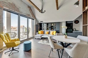 A modern living room with a sofa, yellow armchair, and round dining table. - Grano Residence by Downtown Apartments (Gdansk)