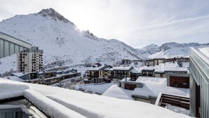 Une ville recouverte de neige, avec des bâtiments et des montagnes en arrière-plan.