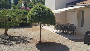 A house with a patio, outdoor furniture, and a small tree. - Quiet Vacation Home - Pets Allowed (La Faute-sur-Mer)