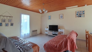 A bedroom with a wooden ceiling, a bed, a TV, and a dresser. - Quiet Vacation Home - Pets Allowed (La Faute-sur-Mer)