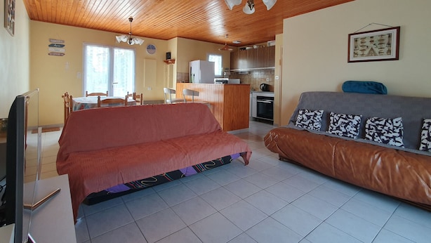 A cozy living room with a sofa, a couch, a TV, and a wooden ceiling. - Quiet Vacation Home - Pets Allowed (La Faute-sur-Mer)