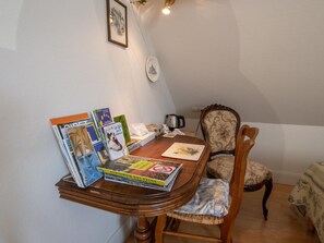 A small dining area with a wooden table, a chair, and a stack of books. - Comfortable family suite with WiFi in Saint-Benoît-sur-Loire, pets allowed (Saint-Benoît-sur-Loire)