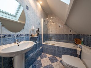 A bathroom with a skylight, a bathtub, a toilet, and a sink. - Comfortable family suite with WiFi in Saint-Benoît-sur-Loire, pets allowed (Saint-Benoît-sur-Loire)
