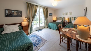 A hotel room with two beds, a dining table, and a small kitchen area. - Room La Loire - Disabled Access, WiFi, Pets Allowed (Saint-Benoît-sur-Loire)