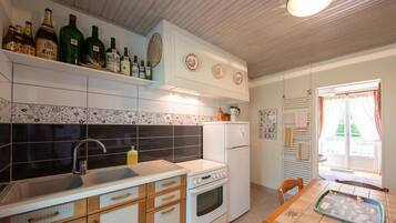 Une cuisine équipée d’un évier, d’une cuisinière, d’un réfrigérateur et d’un coin repas avec une table.
