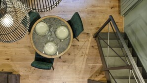A dining area with a round table, four chairs, and hanging light fixtures. - Elaisa s House - RS (Genoa)