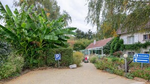 A pathway leading to a building with a parking sign and a sign indicating the entrance. - Charming room with private terrace and wifi in Saint-Benoît-sur-Loire (Saint-Benoît-sur-Loire)