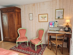 A room with two chairs, a wooden cabinet, a desk with a lamp, and a patterned rug. - Charming room with private terrace and wifi in Saint-Benoît-sur-Loire (Saint-Benoît-sur-Loire)