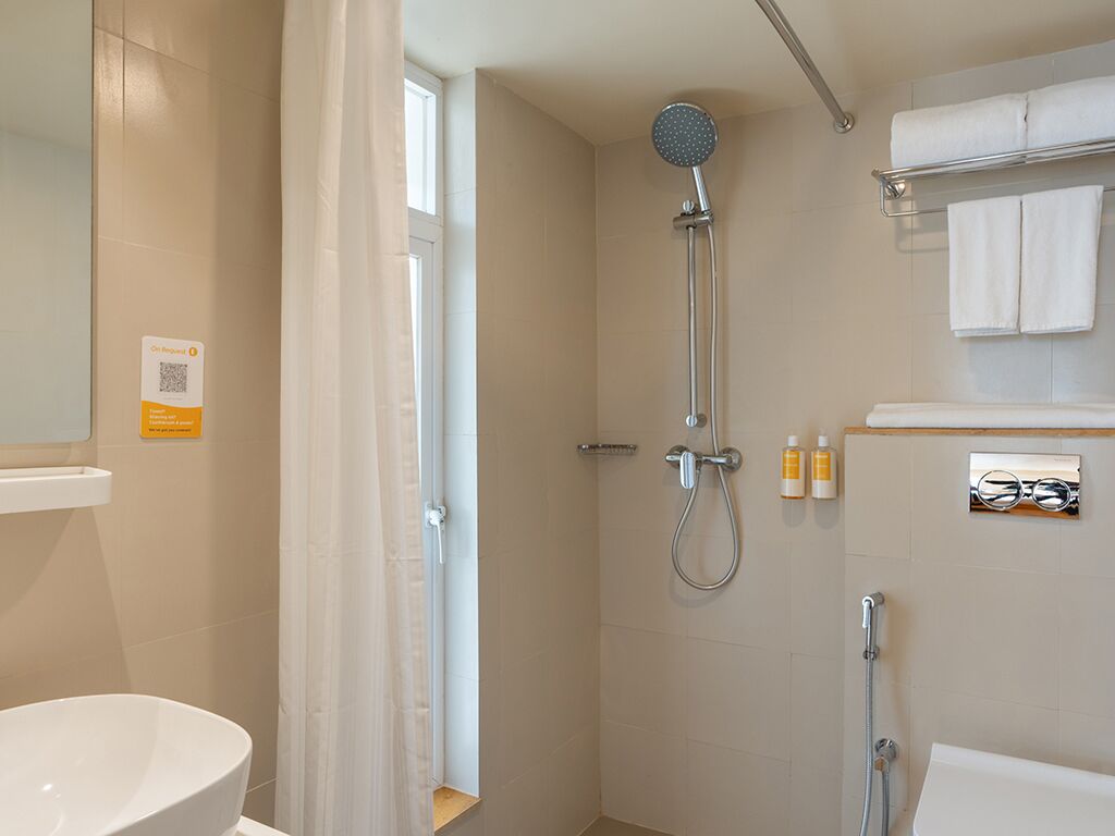 A modern bathroom with a shower, toilet, and sink.
