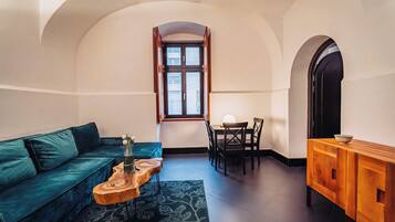 Ein gemütlicher Wohnbereich mit einer Couch, einem Couchtisch, einem Esstisch mit Stühlen und einem Fenster mit Blick.