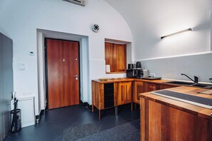 A modern kitchen with wooden cabinetry, a built-in microwave, and a black countertop. - Joy City Stay Paul Chinezu 3 (Timișoara)