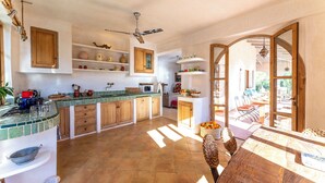 Una cocina amplia con una isla central, armarios de madera y vista al patio exterior.