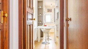 A hallway leading to a bathroom with a white sink and a mirror. - [salernostays] Central apt by duomo | Retro Vibes (Salerno)