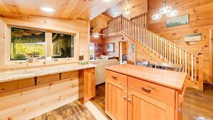 Un interno in legno con cucina, zona pranzo e una scala.