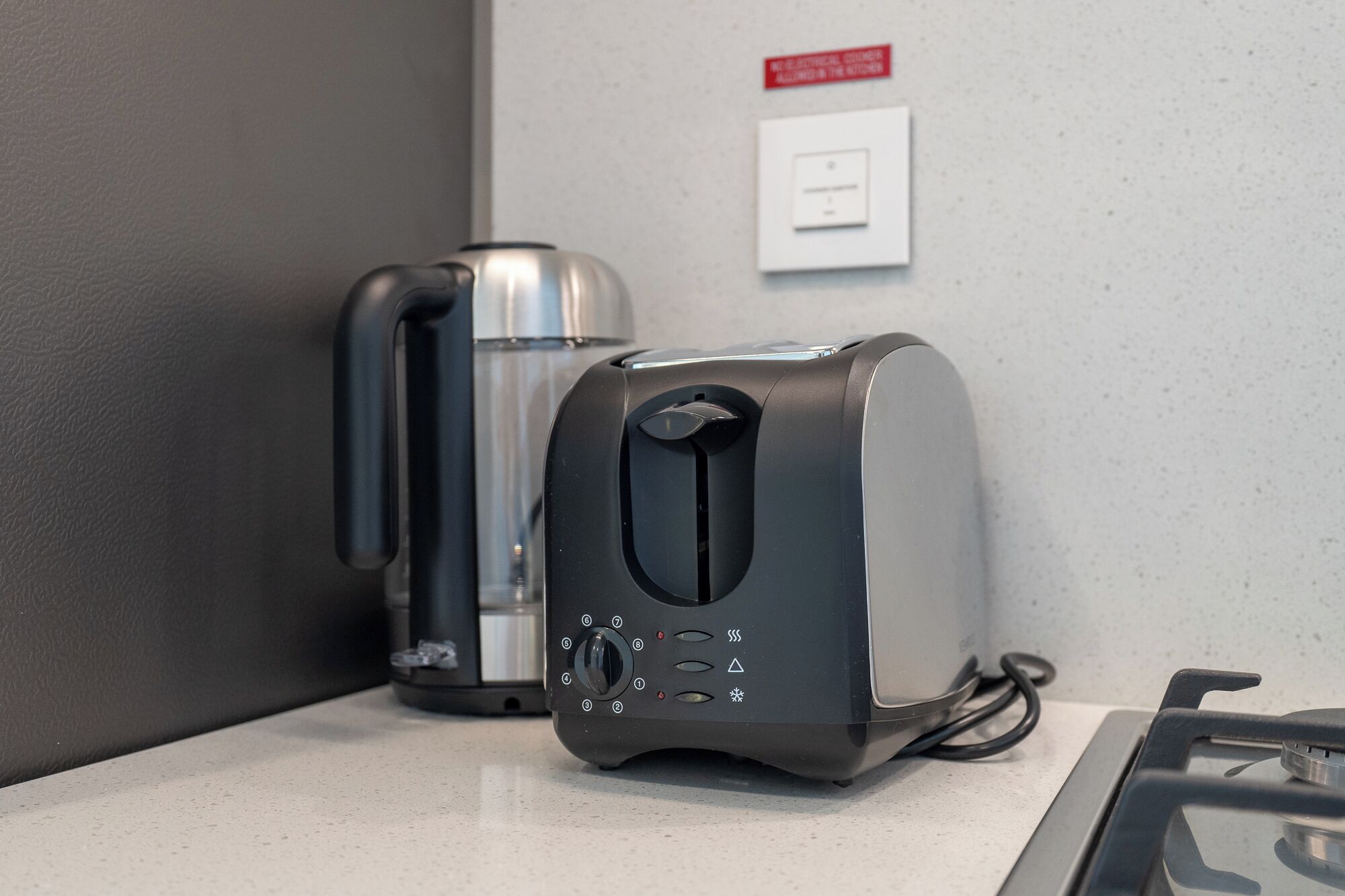 A kitchen area with a toaster and a coffee maker on a countertop.