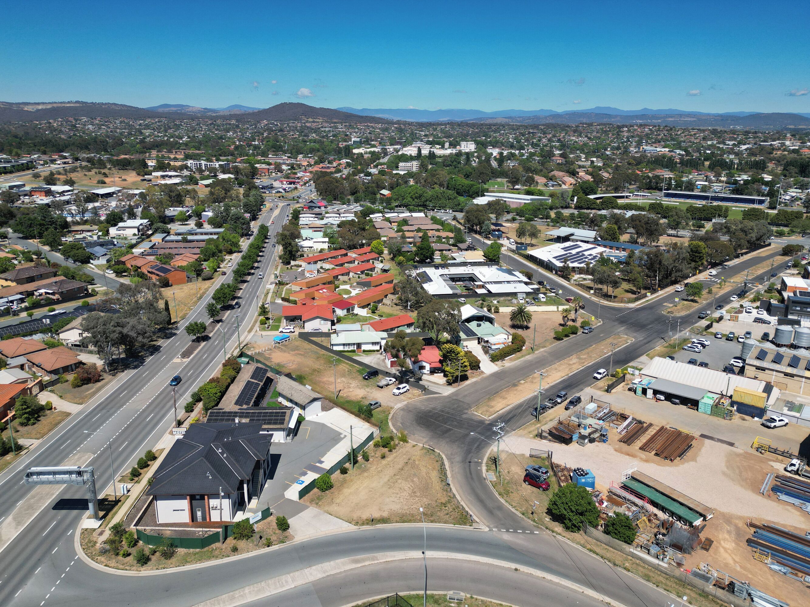 Un quartier résidentiel comprenant des maisons, des rues et un grand bâtiment industriel.