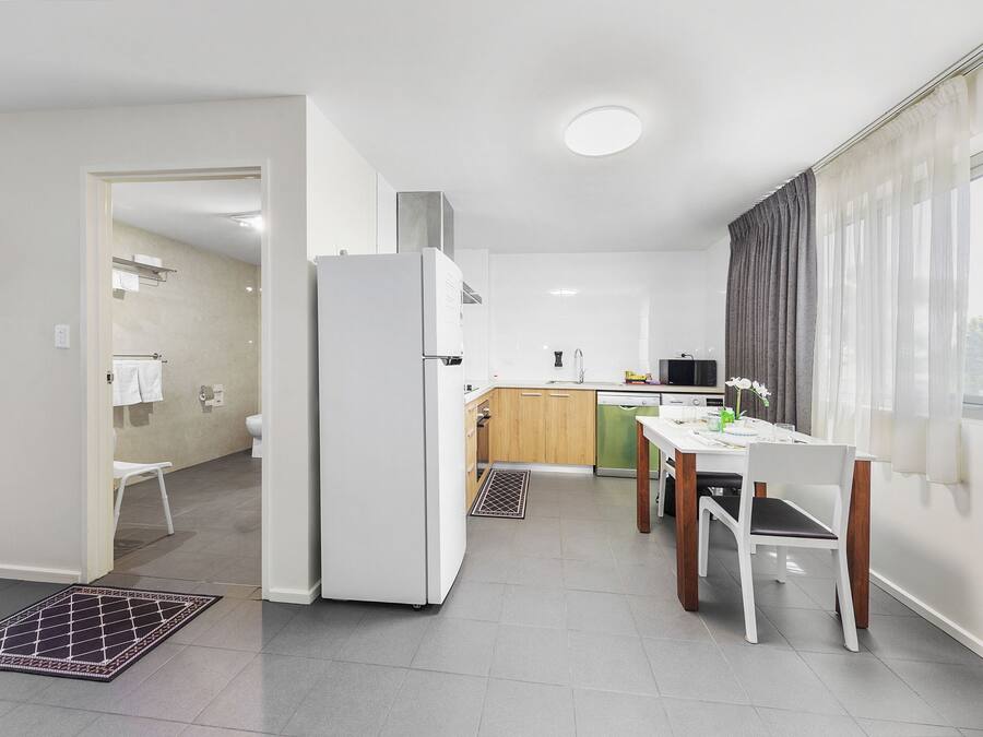 Eine moderne Küche mit Kühlschrank, Spüle und Essbereich.