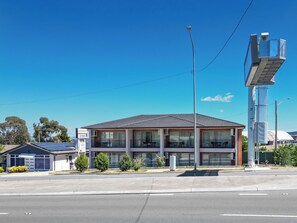 A two-story building with a flat roof, large windows, and a balcony. - Rainbow Motel Queanbeyan (Queanbeyan East)